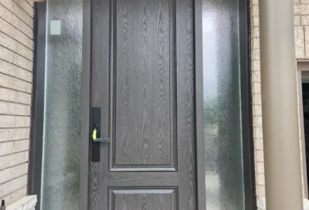 Woodgrain-textured fiberglass entry door with two full-height textured-glass sidelights in Guelph.