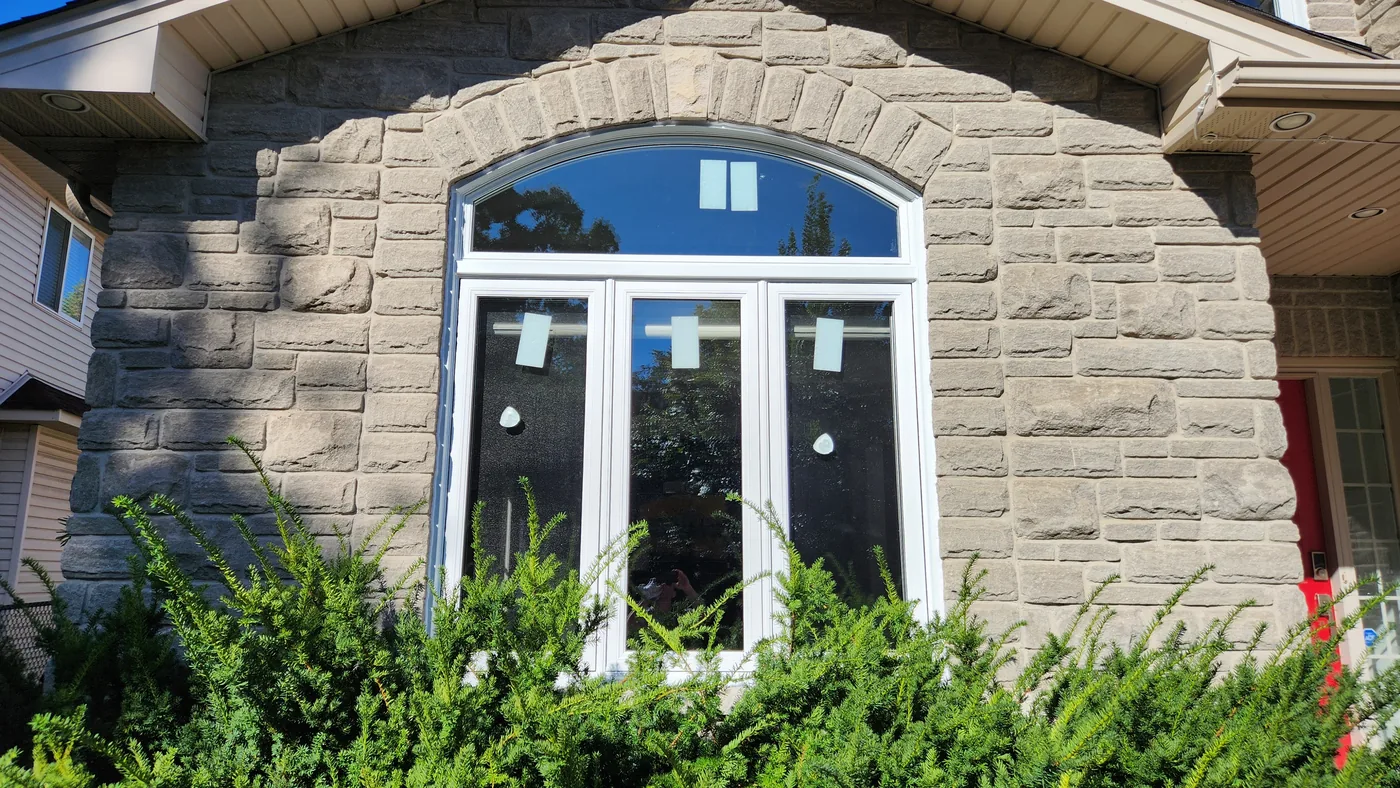 White vinyl window combination with an arched upper section and three tall lower panes at the Hamilton project.